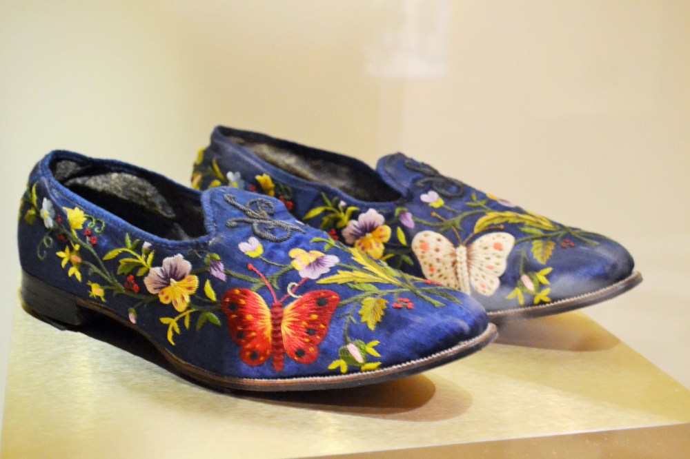 Floral motives served to enliven the grey environments of urban centers by rooting people back to the natural world. Even men in their off-hours got caught up with the floral trend: these “Albert” slippers are hand embodied with pansies and butterflies that are reminiscent of silk moths, the source of silk thread used in the embroidery. Shoes: French, c.1860s Collection of the Bata Shoe Museum)