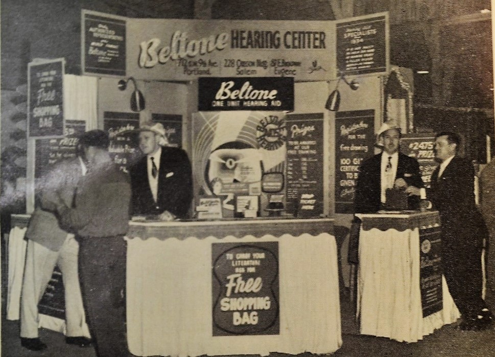 Beltone hearing aid exhibit at the Oregon State Fair, c.1956. The exhibit was designed by Harry L. Marx of Portland to attract and stop people in the aisles. Salesmen were required to wear flashy hats. 