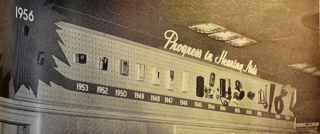 Inside the above store, with a display of "Progress in Hearing Aids," showing the development and miniaturization of hearing aids since 1890s.